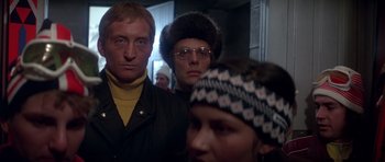 Movie still from “For Your Eyes Only” (1981), directed by John Glen – A group of people standing next to each other in a room; Close Up shot, Low angle