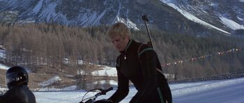 Movie still from “For Your Eyes Only” (1981), directed by John Glen – A man riding a bike on top of a snow covered slope; Medium shot, Low angle