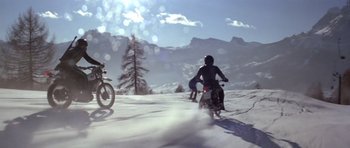 Movie still from “For Your Eyes Only” (1981), directed by John Glen – A group of people riding motorcycles in the snow; Extreme Wide shot, Low angle