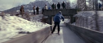 Movie still from “For Your Eyes Only” (1981), directed by John Glen – A man riding skis down the side of a snow covered slope; Wide shot, High angle