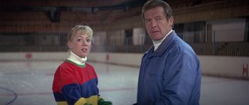 Movie still from “For Your Eyes Only” (1981), directed by John Glen – A man and a woman standing next to each other on a rink; Medium shot, Over the shoulder angle