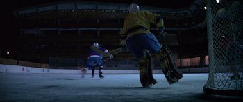 Movie still from “For Your Eyes Only” (1981), directed by John Glen – Two hockey players are playing a game on the ice at night; Wide shot, High angle