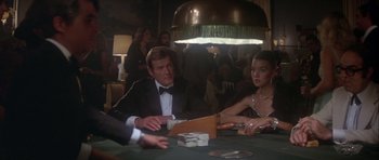 Movie still from “For Your Eyes Only” (1981), directed by John Glen – A man and a woman sitting at a poker table; Medium shot, Over the shoulder angle