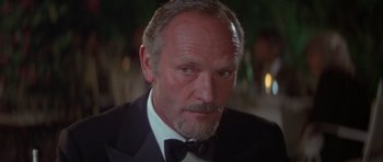 Movie still from “For Your Eyes Only” (1981), directed by John Glen – An older man wearing a tuxedo and a bow tie; Close Up shot, Low angle