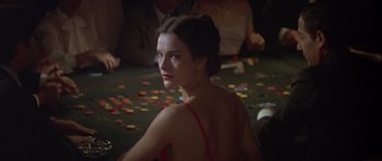 Movie still from “For Your Eyes Only” (1981), directed by John Glen – A woman sitting at a table in front of a pile of chips; Close Up shot, Over the shoulder angle
