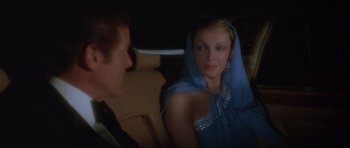 Movie still from “For Your Eyes Only” (1981), directed by John Glen – A man and a woman sitting in the back of a car; Close Up shot, Over the shoulder angle