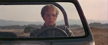 Movie still from “For Your Eyes Only” (1981), directed by John Glen – A man driving a car in the middle of the day; Close Up shot, Low angle