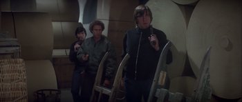 Movie still from “For Your Eyes Only” (1981), directed by John Glen – A group of people standing next to each other in a room; Medium shot, High angle