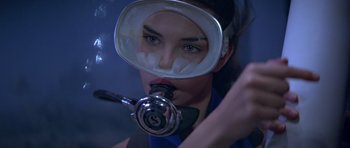 Movie still from “For Your Eyes Only” (1981), directed by John Glen – A woman wearing a gas mask in a dark room; Close Up shot, High angle