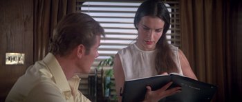 Movie still from “For Your Eyes Only” (1981), directed by John Glen – A man and a woman are looking at a book; Close Up shot, Over the shoulder angle