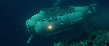 Movie still from “For Your Eyes Only” (1981), directed by John Glen – An underwater view of an underwater submarine with lights on it; Extreme Wide shot, High angle