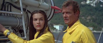 Movie still from “For Your Eyes Only” (1981), directed by John Glen – A man and a woman standing next to each other; Close Up shot, Low angle