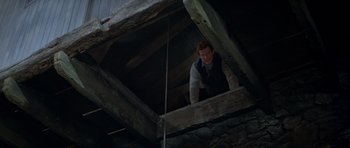 Movie still from “For Your Eyes Only” (1981), directed by John Glen – A man standing inside of an old building; Medium shot, Low angle