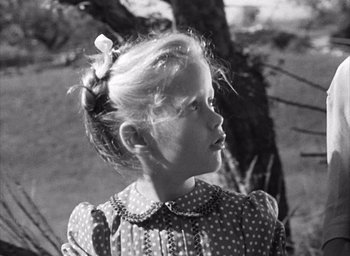 Movie still from “Forbidden Games” (1952), directed by René Clément – A little girl in a polka dot dress looking off to her left; Close Up shot, Low angle