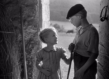 Movie still from “Forbidden Games” (1952), directed by René Clément – A young boy and girl standing next to each other in front of a fence; Medium shot, Low angle