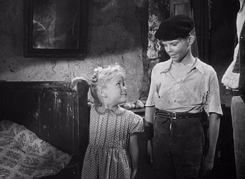 Movie still from “Forbidden Games” (1952), directed by René Clément – A boy and a little girl standing next to each other; Medium shot, Over the shoulder angle