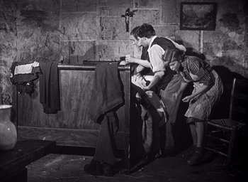 Movie still from “Forbidden Games” (1952), directed by René Clément – A couple of people standing next to each other in a room; Wide shot, High angle