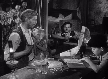 Movie still from “Forbidden Games” (1952), directed by René Clément – An old black and white photo of a man holding a child; Medium shot, Over the shoulder angle