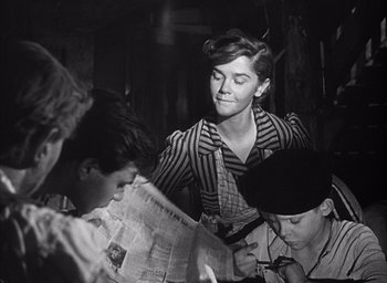 Movie still from “Forbidden Games” (1952), directed by René Clément – An old photo of a woman looking at a newspaper; Medium shot, Low angle