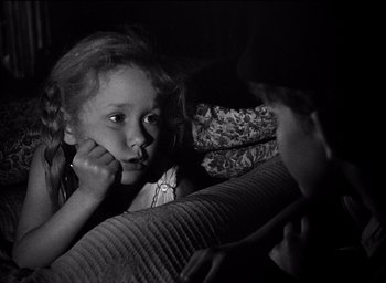 Movie still from “Forbidden Games” (1952), directed by René Clément – A little girl holding her hand up to her face; Close Up shot, Over the shoulder angle