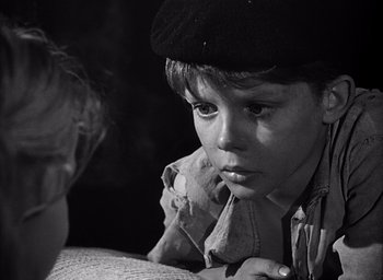 Movie still from “Forbidden Games” (1952), directed by René Clément – A young boy wearing a hat looking at another young boy; Close Up shot, High angle