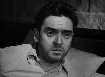 Movie still from “Forbidden Games” (1952), directed by René Clément – Black and white photograph of a man looking at the camera; Close Up shot, Low angle