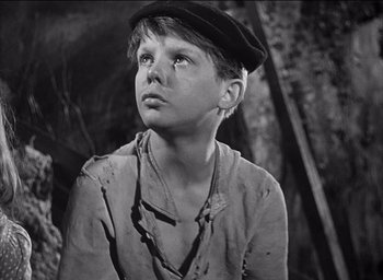 Movie still from “Forbidden Games” (1952), directed by René Clément – A young boy wearing a hat looking up at the sky; Close Up shot, High angle