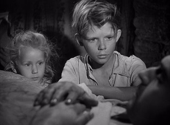 Movie still from “Forbidden Games” (1952), directed by René Clément – A young boy and a little girl sitting next to each other; Close Up shot, High angle