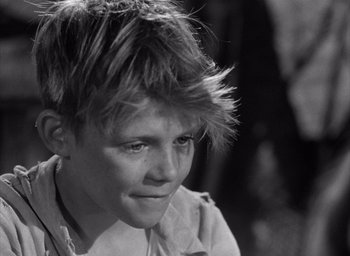 Movie still from “Forbidden Games” (1952), directed by René Clément – A young boy with a messy hair style; Close Up shot, High angle