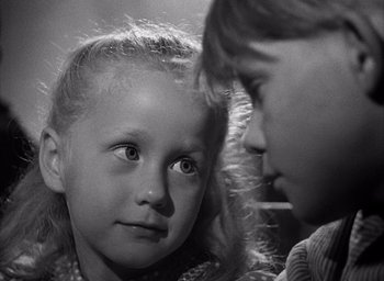 Movie still from “Forbidden Games” (1952), directed by René Clément – Two young children looking at each other in black and white photo; Close Up shot, Over the shoulder angle