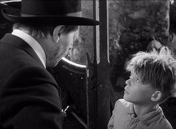 Movie still from “Forbidden Games” (1952), directed by René Clément – A man and a boy are talking to each other; Close Up shot, Over the shoulder angle