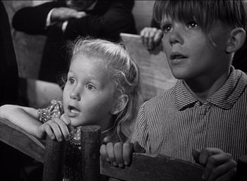 Movie still from “Forbidden Games” (1952), directed by René Clément – A young girl and a young boy sitting next to each other; Close Up shot, Low angle