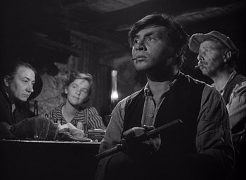 Movie still from “Forbidden Games” (1952), directed by René Clément – An old photo of people sitting at a table; Medium shot, Low angle