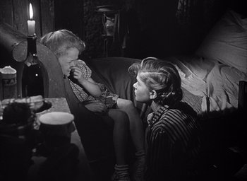 Movie still from “Forbidden Games” (1952), directed by René Clément – Two young women sitting on a couch in a living room; Medium shot, Over the shoulder angle