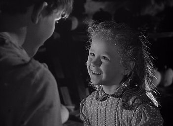 Movie still from “Forbidden Games” (1952), directed by René Clément – A young girl and a young boy smiling at each other; Close Up shot, Over the shoulder angle