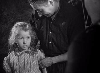 Movie still from “Forbidden Games” (1952), directed by René Clément – An old photo of a man and a little girl; Medium shot, Over the shoulder angle