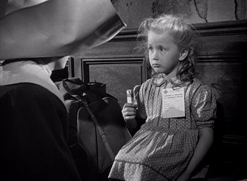 Movie still from “Forbidden Games” (1952), directed by René Clément – A little girl is holding a cell phone in her hand; Medium shot, Over the shoulder angle