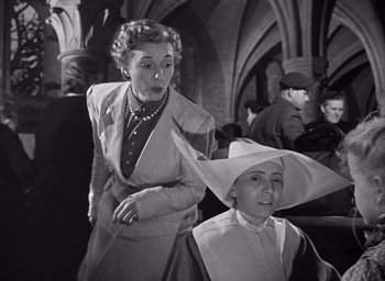 Movie still from “Forbidden Games” (1952), directed by René Clément – An older woman and a younger woman in hats; Medium shot, Low angle