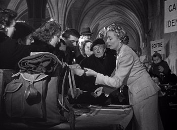 Movie still from “Forbidden Games” (1952), directed by René Clément – An old black and white photo of a group of people; Medium shot, Over the shoulder angle