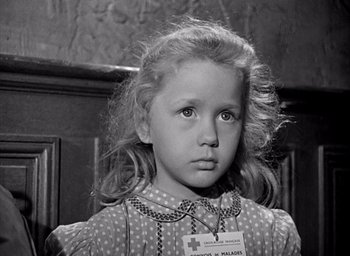 Movie still from “Forbidden Games” (1952), directed by René Clément – A little girl with a name tag on her dress; Close Up shot, Over the shoulder angle