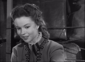 Movie still from “Fort Apache” (1948), directed by John Ford – A young woman in a dress smiling for the camera; Close Up shot, High angle