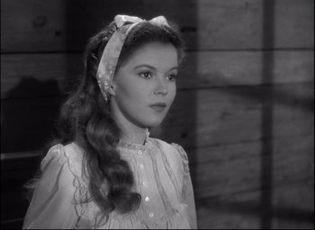 Movie still from “Fort Apache” (1948), directed by John Ford – A woman with long hair wearing a white dress and a headband; Close Up shot, Over the shoulder angle