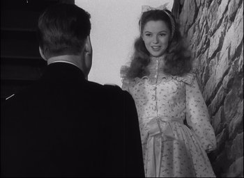 Movie still from “Fort Apache” (1948), directed by John Ford – A young woman in a dress standing in front of a man; Medium shot, Over the shoulder angle