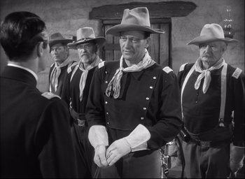 Movie still from “Fort Apache” (1948), directed by John Ford – A group of men standing next to each other; Medium shot, Over the shoulder angle