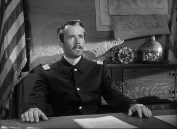 A man sitting at a table wearing a military uniform