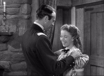 Movie still from “Fort Apache” (1948), directed by John Ford – A man and a woman dancing in front of a stone wall; Medium shot, High angle