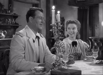 Movie still from “Fort Apache” (1948), directed by John Ford – A man and a woman sitting at a dinner table; Medium shot, Over the shoulder angle