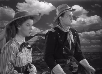Movie still from “Fort Apache” (1948), directed by John Ford – A man and a woman standing next to each other; Medium shot, Low angle