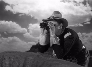 Movie still from “Fort Apache” (1948), directed by John Ford – A man with a hat and binoculars looking at the sky; Medium shot, Low angle