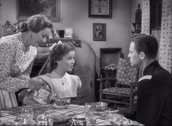 Movie still from “Fort Apache” (1948), directed by John Ford – An old photo of a woman and two children at a table; Medium shot, High angle